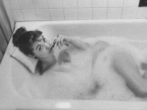 unexposed nude woman in the bathtub amid the bubbles while smoking a cigarette u L P3Q1AT0